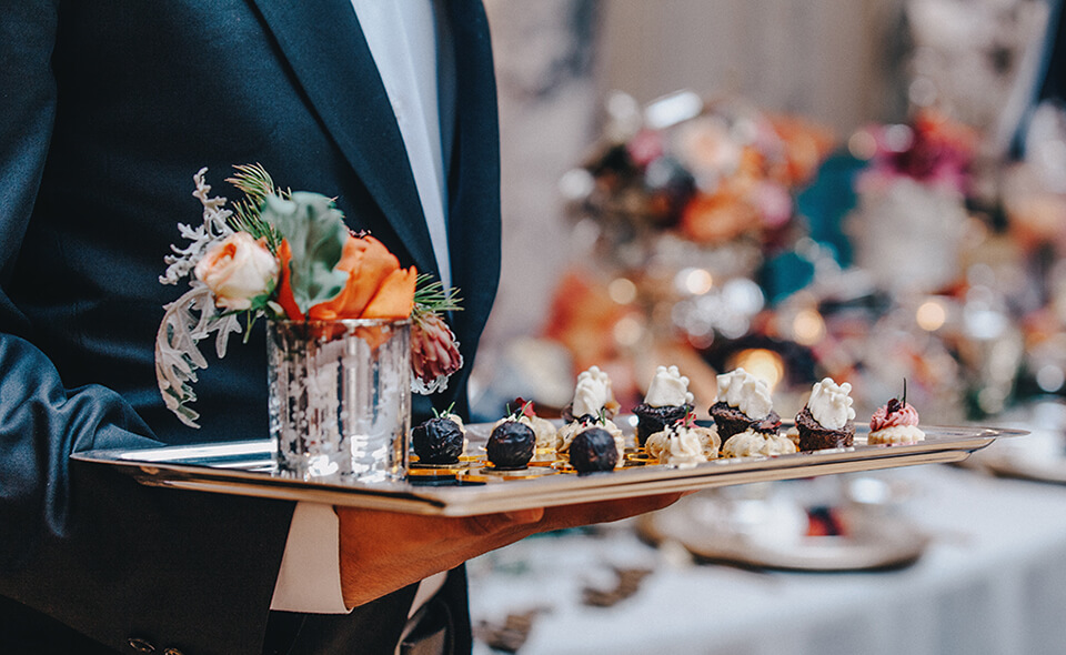 A waiter holding a tray of food