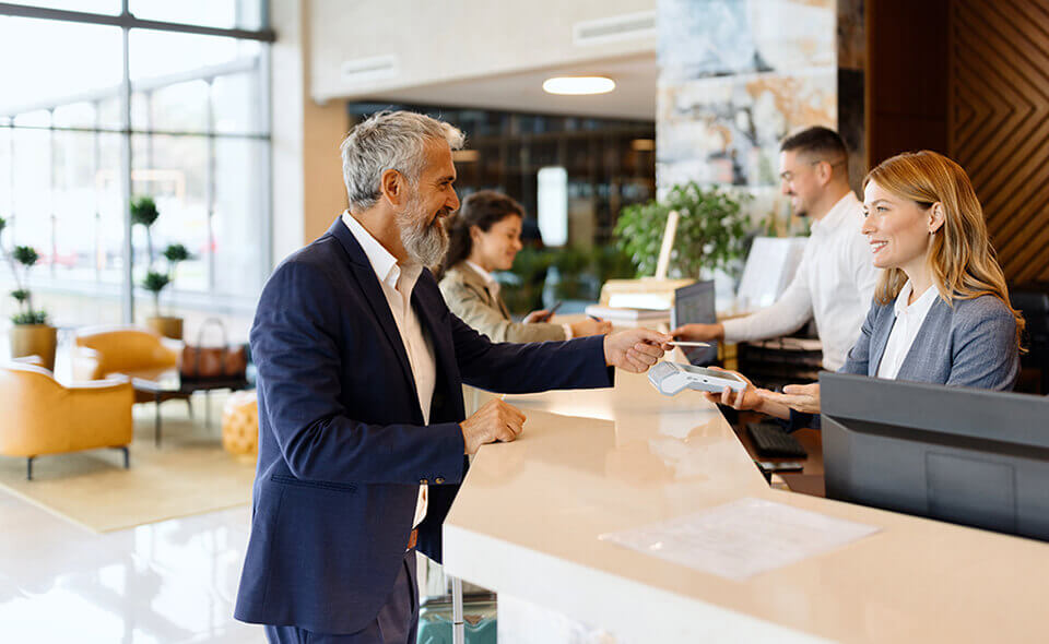 A man handing over a card to check into hotel